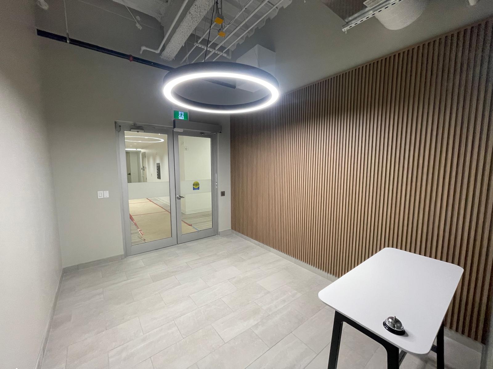 345 King Suite 200 corridor with wood-slat feature wall and ring lighting