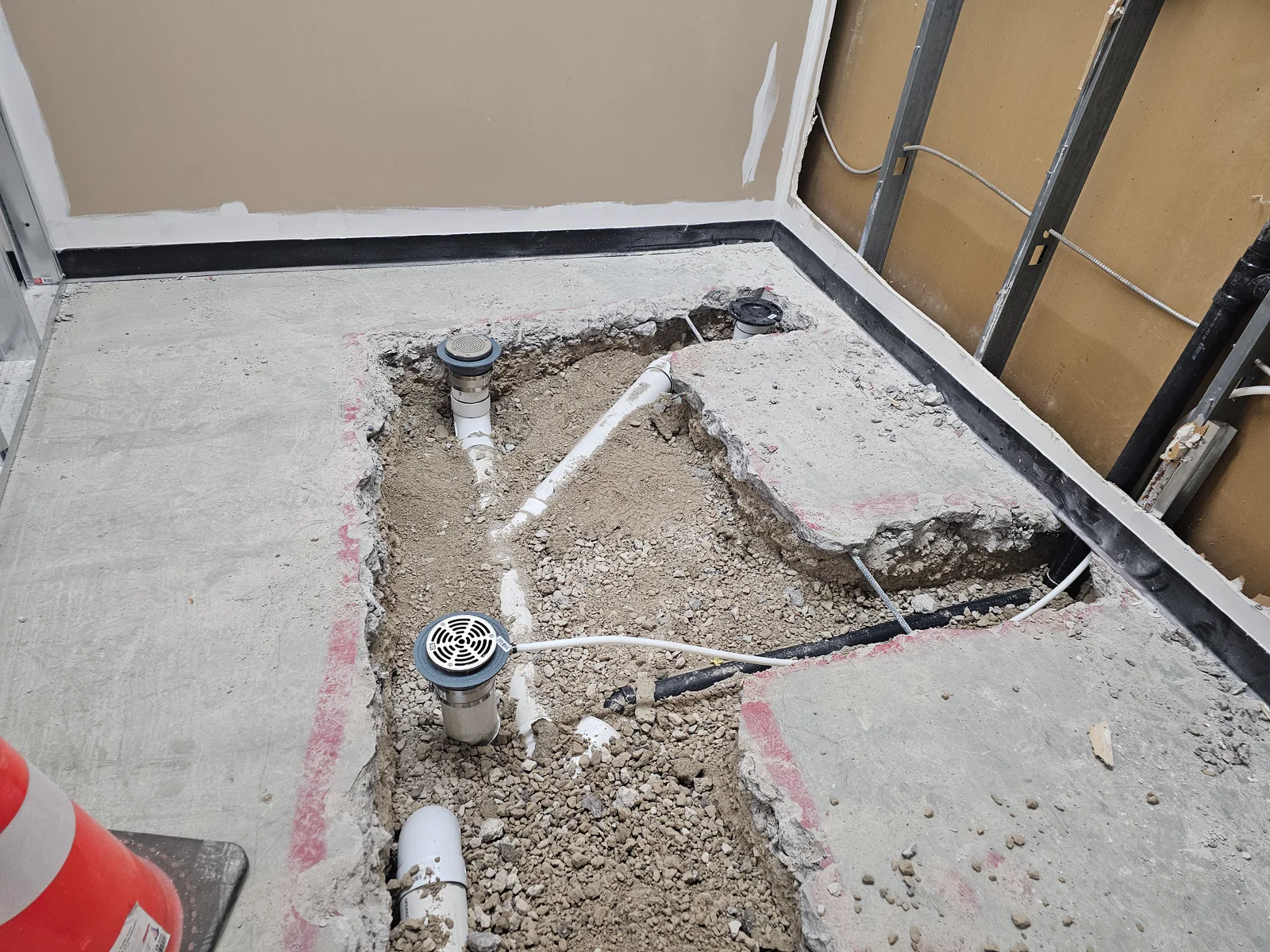 Floor drains and pipe rough-in documented inside the open slab